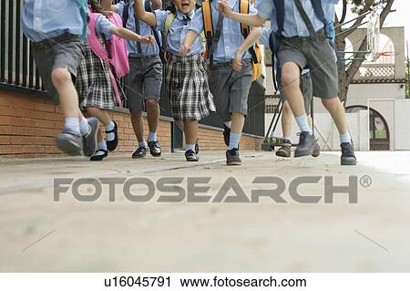 Stock Image - School children running low angle. Fotosearch