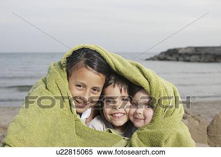 Three young children in towel on beach View Large Photo Image Stock Photography - Three young children in towel on beach. Fotosearch