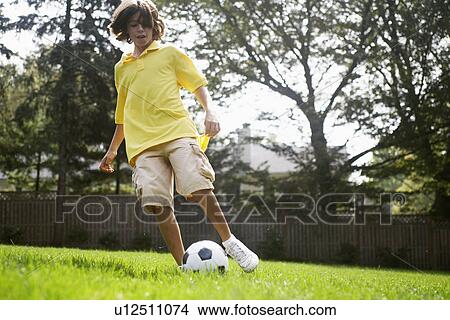 Boy (12-13) playing with soccer ball View Large Photo Image Picture - Boy (12-13) playing with soccer ball. Fotosearch