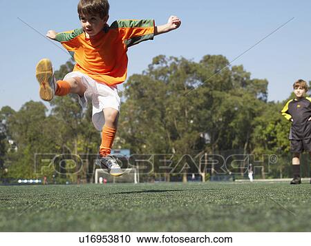 Boy kicking in soccer field View Large Photo Image Stock Image - Boy kicking in soccer field. Fotosearch