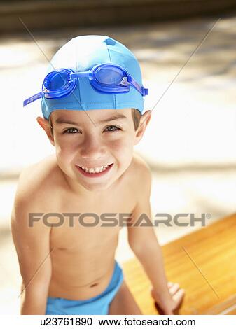 Boy wearing swimming cap and goggles (portrait, high angle view) View Large Photo Image Stock Image - Boy wearing swimming cap and goggles (portrait, high angle view). Fotosearch