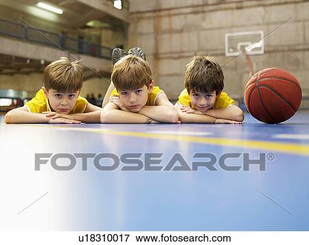 Boys lying on floor near basketball (portrait) View Large Photo Image Stock Photo - Boys lying on floor near basketball (portrait). Fotosearch
