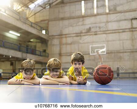 Boys lying on floor near basketball (portrait) View Large Photo Image Stock Photograph - Boys lying on floor near basketball (portrait). Fotosearch