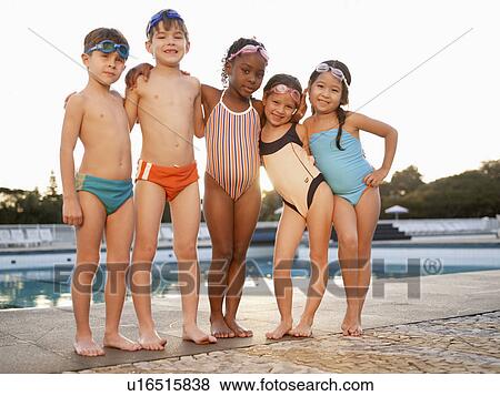 Stock Photo - Children posing by swimming pool (portrait, low angle view). Fotosearch