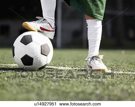 Stock Image - Child's foot on soccer ball (close-up). Fotosearch