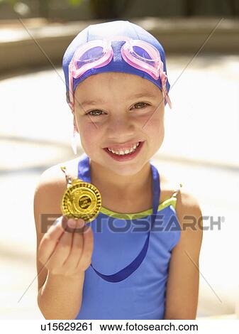 Girl in swimming costume holding medal (portrait) View Large Photo Image Stock Image - Girl in swimming costume holding medal (portrait). Fotosearch