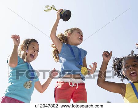Girls celebrating medals and trophies (low angle view) View Large Photo Image Stock Image - Girls celebrating medals and trophies (low angle view). Fotosearch