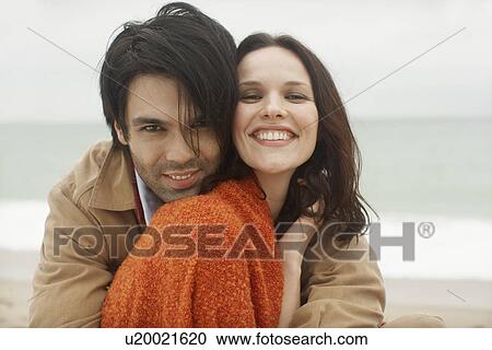 Stock Image - Young couple at beach (portrait). Fotosearch