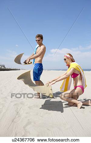 Young couple spreading beach mats on beach, Spring Lake, New Jersey, USA View Large Photo Image Stock Photograph - Young couple spreading beach mats on beach, Spring Lake, New Jersey, USA. Fotosearch