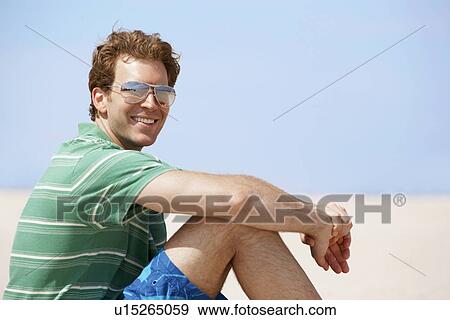 Young man smiling at beach View Large Photo Image Stock Photo - Young man smiling at beach. Fotosearch