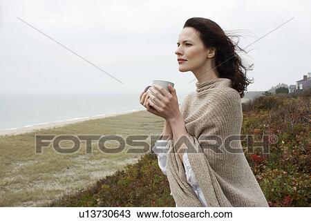 Young woman drinking coffee at beach View Large Photo Image Stock Image - Young woman drinking coffee at beach. Fotosearch