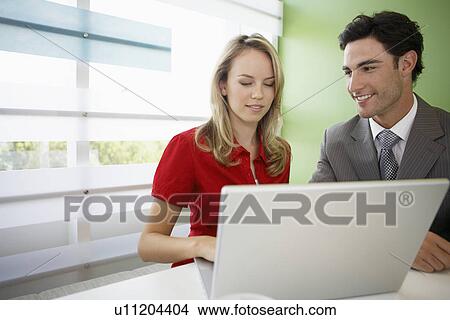 Businesswoman and businessman using laptop View Large Photo Image Picture - Businesswoman and businessman using laptop. Fotosearch