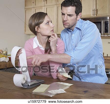 Mid-Adult Couple Examining Receipts View Large Photo Image Stock Photo - Mid-Adult Couple Examining Receipts. Fotosearch