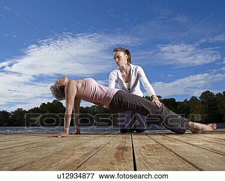 Mid Adult Woman Teaching Mature Woman Yoga View Large Photo Image Stock Photo - Mid Adult Woman Teaching Mature Woman Yoga. Fotosearch
