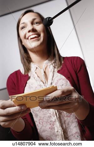 Picture - Student with paper notes giving presentation. Fotosearch