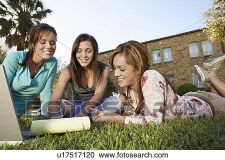 Stock Image - Three female students studying in park. Fotosearch