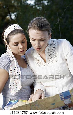 Two women reading road map View Large Photo Image Stock Photo - Two women reading road map. Fotosearch