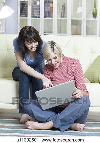Stock Image - Two Young Women Using Laptop. Fotosearch