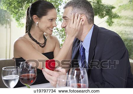 Woman touching man's face, man holding gift View Large Photo Image Picture - Woman touching man's face, man holding gift. Fotosearch