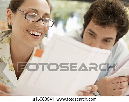 Young couple looking at bills View Large Photo Image Stock Image - Young couple looking at bills. Fotosearch