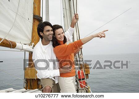 Young couple looking at view in sailboat View Large Photo Image Stock Photo - Young couple looking at view in sailboat. Fotosearch