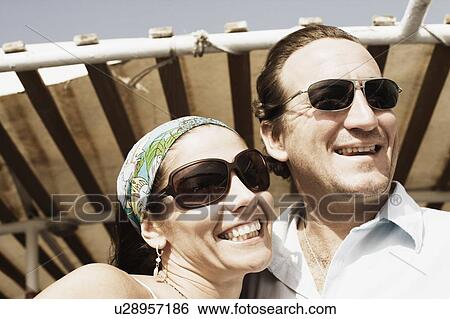 Close-up of a mid adult couple smiling View Large Photo Image Stock Photograph - Close-up of a mid adult couple smiling. Fotosearch