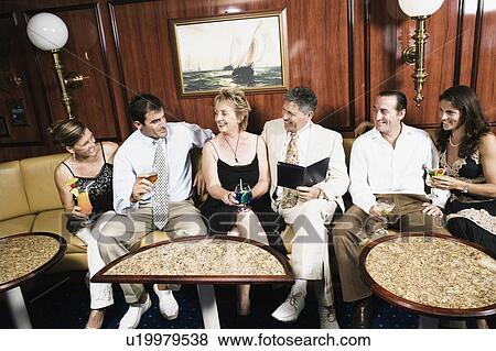 Group of people holding glasses of cocktail and smiling View Large Photo Image Stock Photo - Group of people holding glasses of cocktail and smiling. Fotosearch