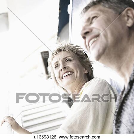 Low angle view of a couple standing on the staircase of a cruise ship and smiling View Large Photo Image Stock Photograph - Low angle view of a couple standing on the staircase of a cruise ship and smiling. Fotosearch