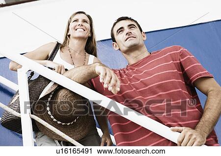 Low angle view of a mid adult couple standing on the staircase of a cruise ship and smiling View Large Photo Image Stock Image - Low angle view of a mid adult couple standing on the staircase of a cruise ship and smiling. Fotosearch