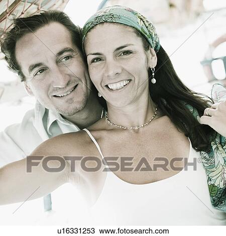 Stock Image - Mid adult couple smiling. Fotosearch