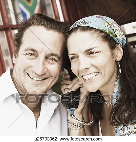 Mid adult couple talking on the telephone View Large Photo Image Stock Image - Mid adult couple talking on the telephone. Fotosearch