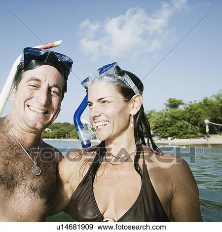 Portrait of a mid adult couple smiling on the beach View Large Photo Image Stock Photo - Portrait of a mid adult couple smiling on the beach. Fotosearch
