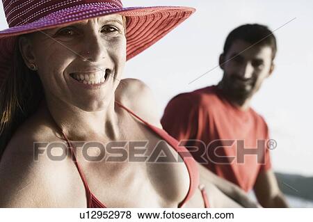 Portrait of a mid adult woman clenching her teeth with a mid adult man sitting beside her View Large Photo Image Stock Photo - Portrait of a mid adult woman clenching her teeth with a mid adult man sitting beside her. Fotosearch