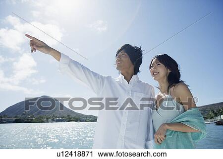 Stock Image - A young couple standing together. Fotosearch