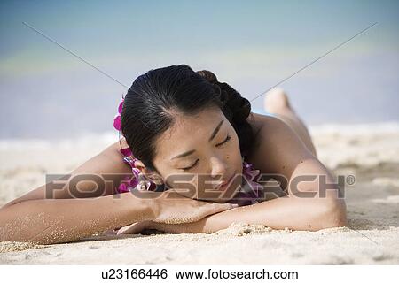 Close-up of a young woman sleeping on sand at beach View Large Photo Image Stock Photograph - Close-up of a young woman sleeping on sand at beach. Fotosearch
