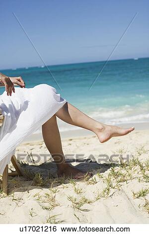 Low section of a woman sitting on chair View Large Photo Image Stock Photograph - Low section of a woman sitting on chair. Fotosearch