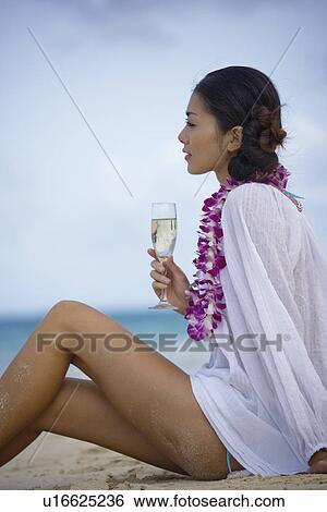 Profile of a young woman sitting at beach with wineglass View Large Photo Image Stock Photograph - Profile of a young woman sitting at beach with wineglass. Fotosearch
