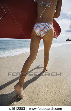 Stock Image - View of a young woman running on beach. Fotosearch
