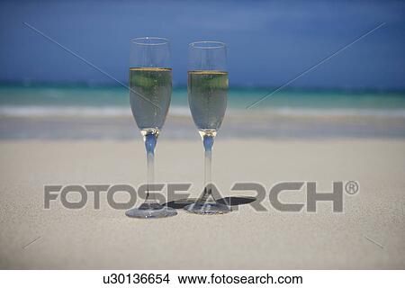 Picture - Wineglasses filled with drink in foreground. Fotosearch