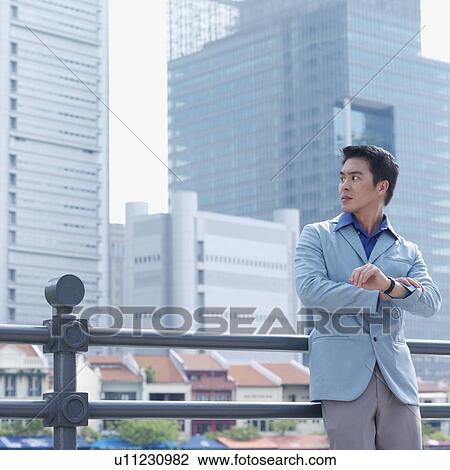 Businessman leaning against a railing and staring at the river View Large Photo Image Stock Image - Businessman leaning against a railing and staring at the river. Fotosearch