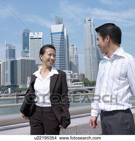Businesswoman smiling with a businessman View Large Photo Image Picture - Businesswoman smiling with a businessman. Fotosearch