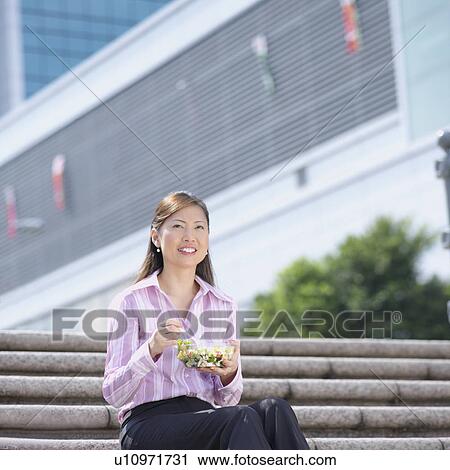 Low angle view of a businesswoman holding a bowl of salad View Large Photo Image Stock Image - Low angle view of a businesswoman holding a bowl of salad. Fotosearch