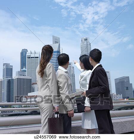 Low angle view of a businesswoman pointing towards buildings View Large Photo Image Stock Photo - Low angle view of a businesswoman pointing towards buildings. Fotosearch