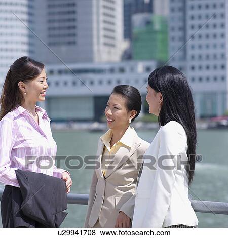 Stock Photo - Three businesswomen talking to each other. Fotosearch