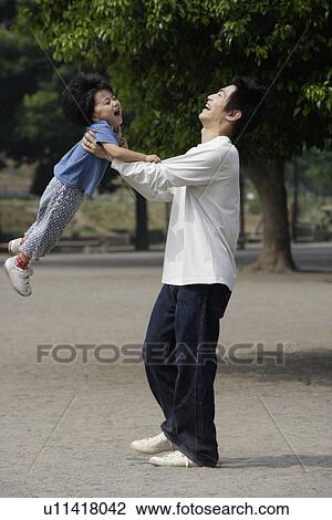 A father holding his son high up in air View Large Photo Image Stock Image - A father holding his son high up in air. Fotosearch