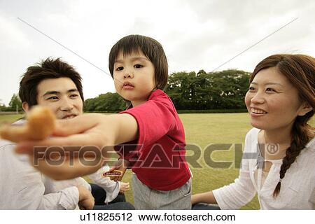 A small boy offering a piece of some edible as the parents looks on View Large Photo Image Stock Image - A small boy offering a piece of some edible as the parents looks on. Fotosearch