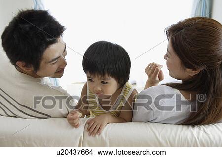 A young couple with a boy sitting on sofa View Large Photo Image Picture - A young couple with a boy sitting on sofa. Fotosearch