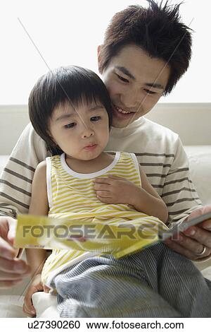 A young father reading a book to his son View Large Photo Image Stock Image - A young father reading a book to his son. Fotosearch