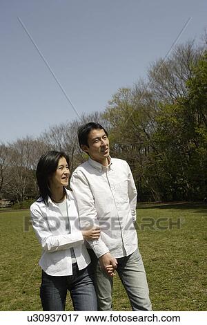 A young couple standing in garden View Large Photo Image Stock Photo - A young couple standing in garden. Fotosearch