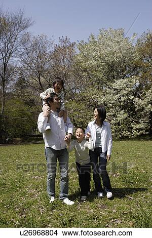 Picture - Family smiling in garden. Fotosearch